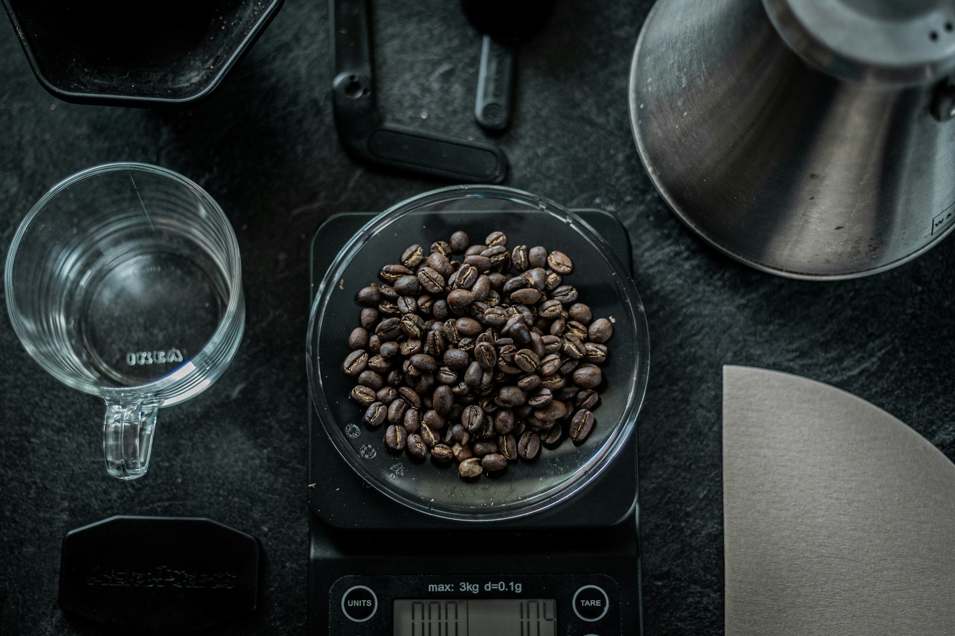 Cafea proaspăt prăjită cântărită cu precizie — prospețimea și grija sunt vizibile înainte de prima sorbitură