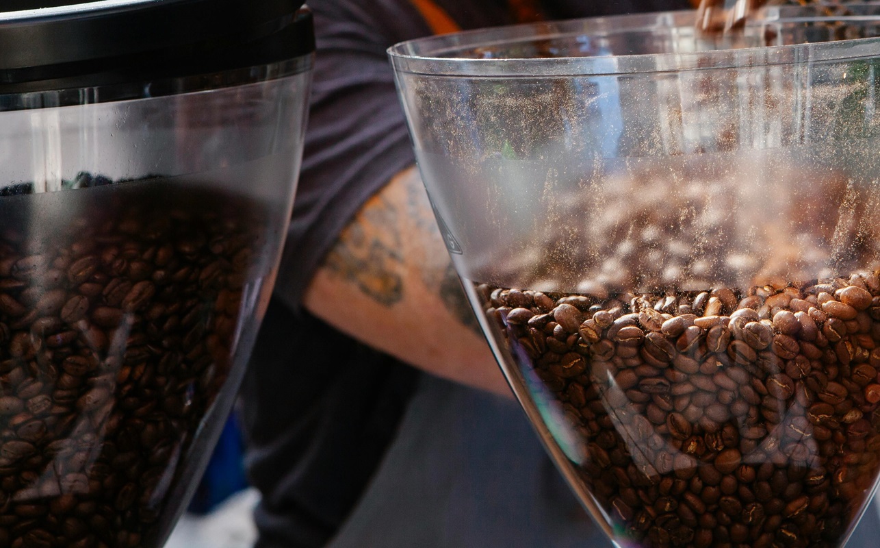 Boabe proaspăt prăjite în râșniță — măcinarea uniformă este cheia unui espresso bun